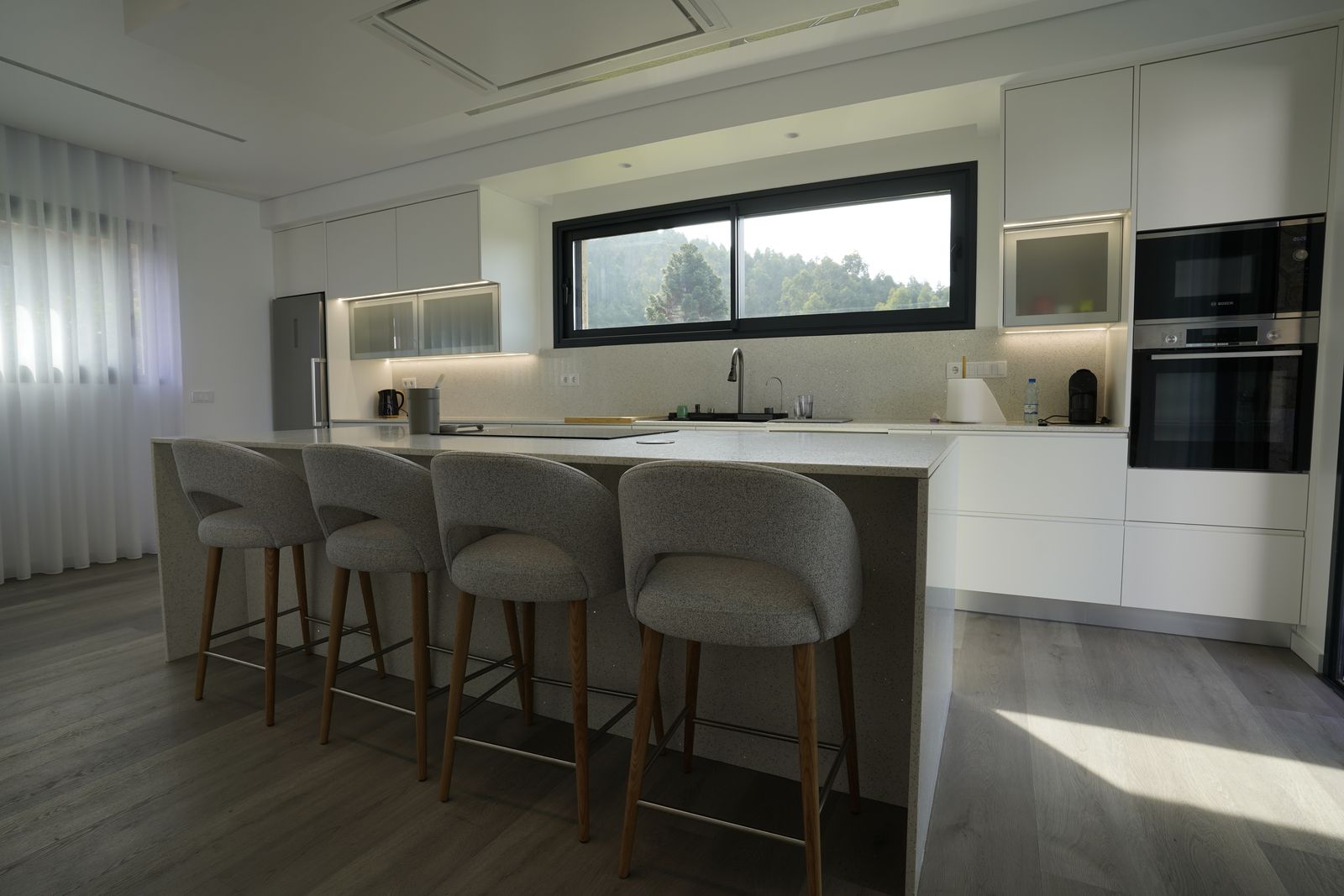 Cozinha equipada com ilha e bancos altos