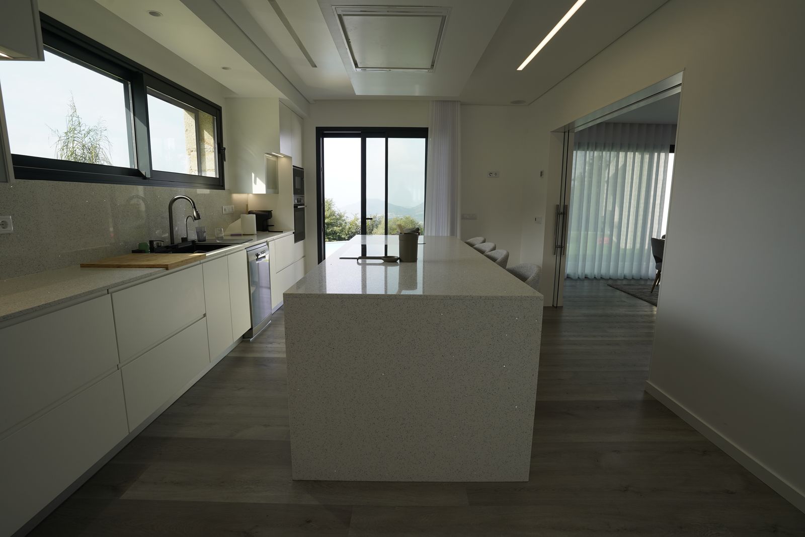 Cozinha com ilha em quartzo e acesso ao exterior